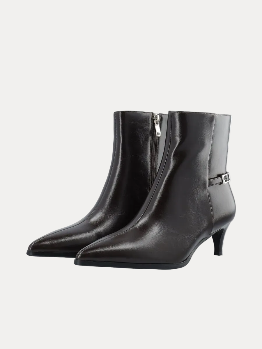 A pair of black leather ankle boots with pointed toes, low kitten heels, side zippers, and a small silver buckle detail on the outer side, shown against a plain white background.
