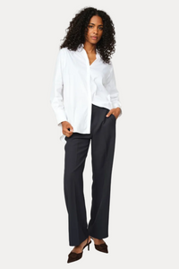 Woman wearing a white blouse and black pants on a white background