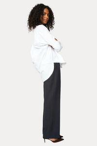 Woman wearing a white blouse and black pants on a white background
