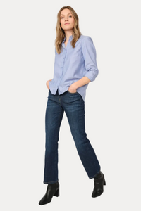 Woman wearing a light blue striped shirt and dark blue jeans on a white background