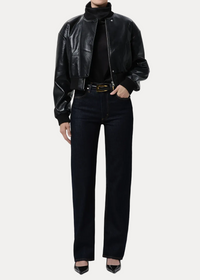 Person wearing a black leather jacket, black turtleneck, black jeans, and black shoes on a white background