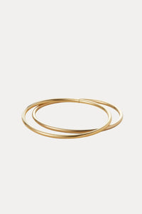 Set of gold bangles on a light beige background