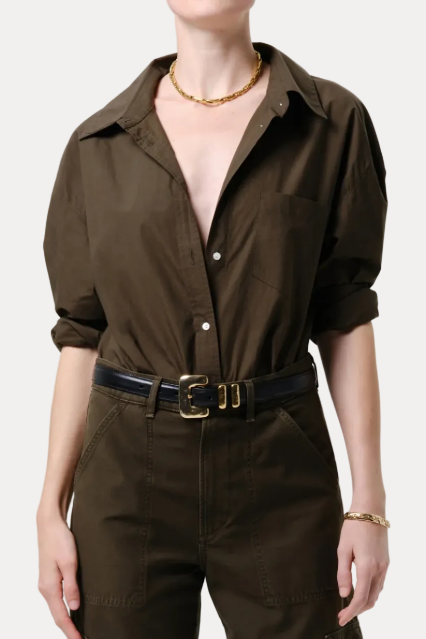 Person wearing a brown jumpsuit with a belt on a plain background