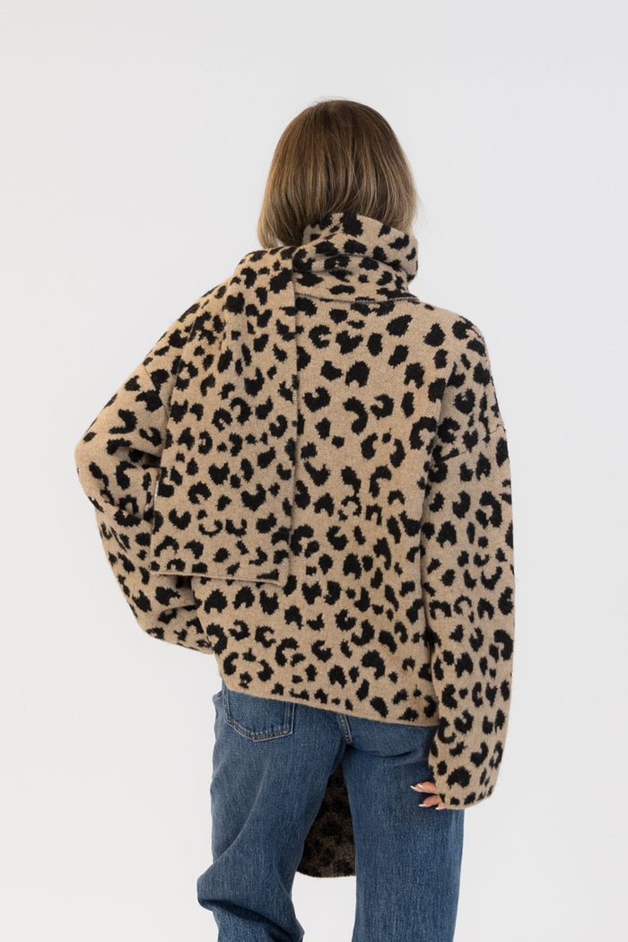 Person wearing a leopard print jacket and blue jeans on a white background