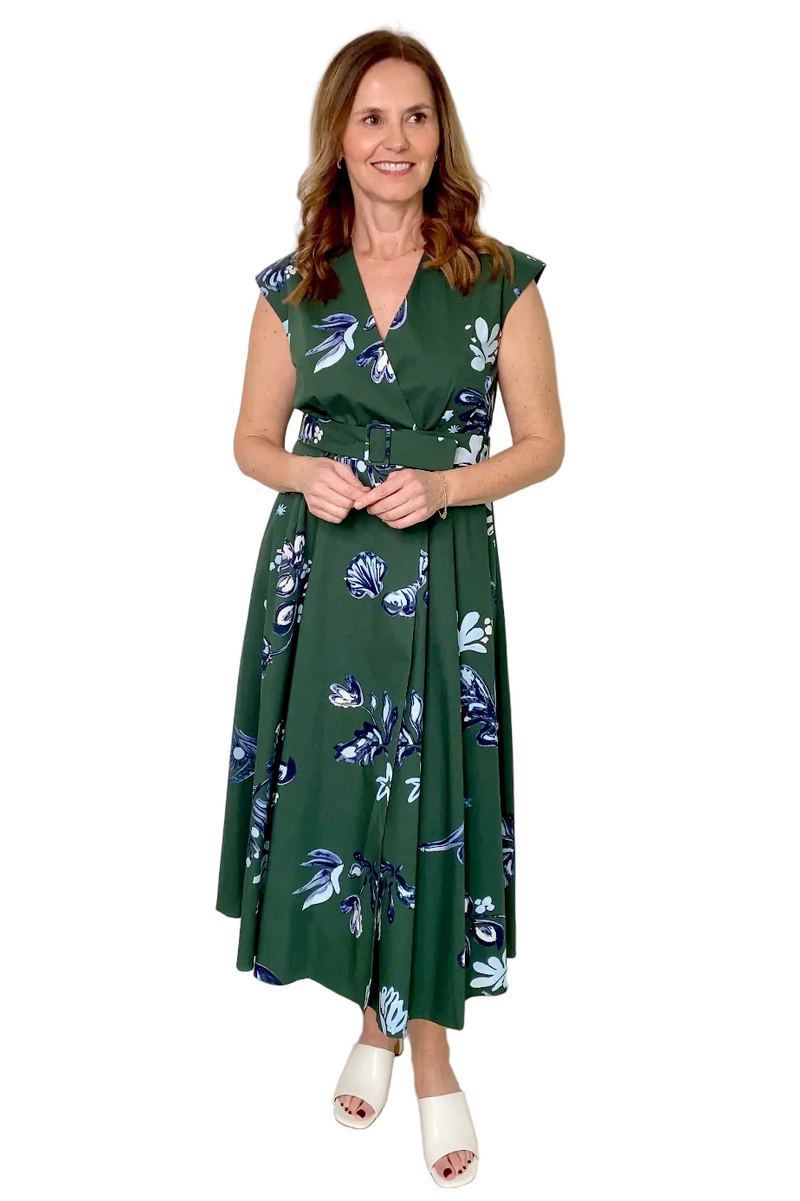 Woman wearing a green floral dress against a white background