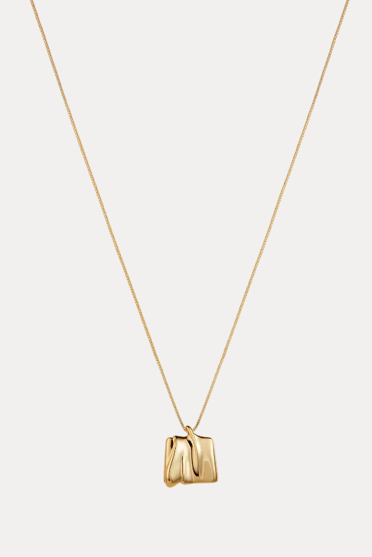 Gold necklace with a unique pendant on a white background