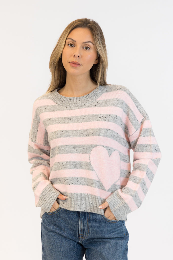 Woman wearing a striped sweater with a heart design on a white background