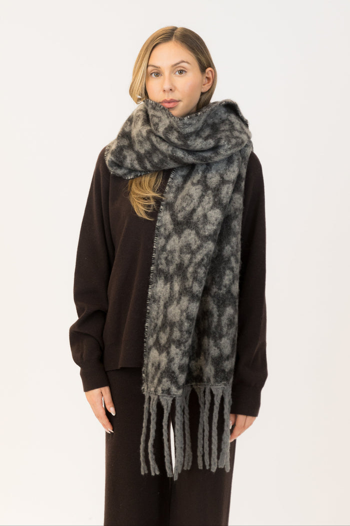 Woman wearing a gray patterned scarf on a white background