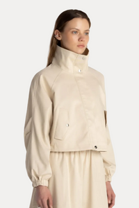 Woman wearing a beige jacket and skirt set on a white background