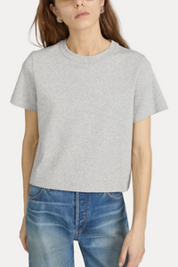 Person wearing a gray t-shirt and blue jeans on a plain background