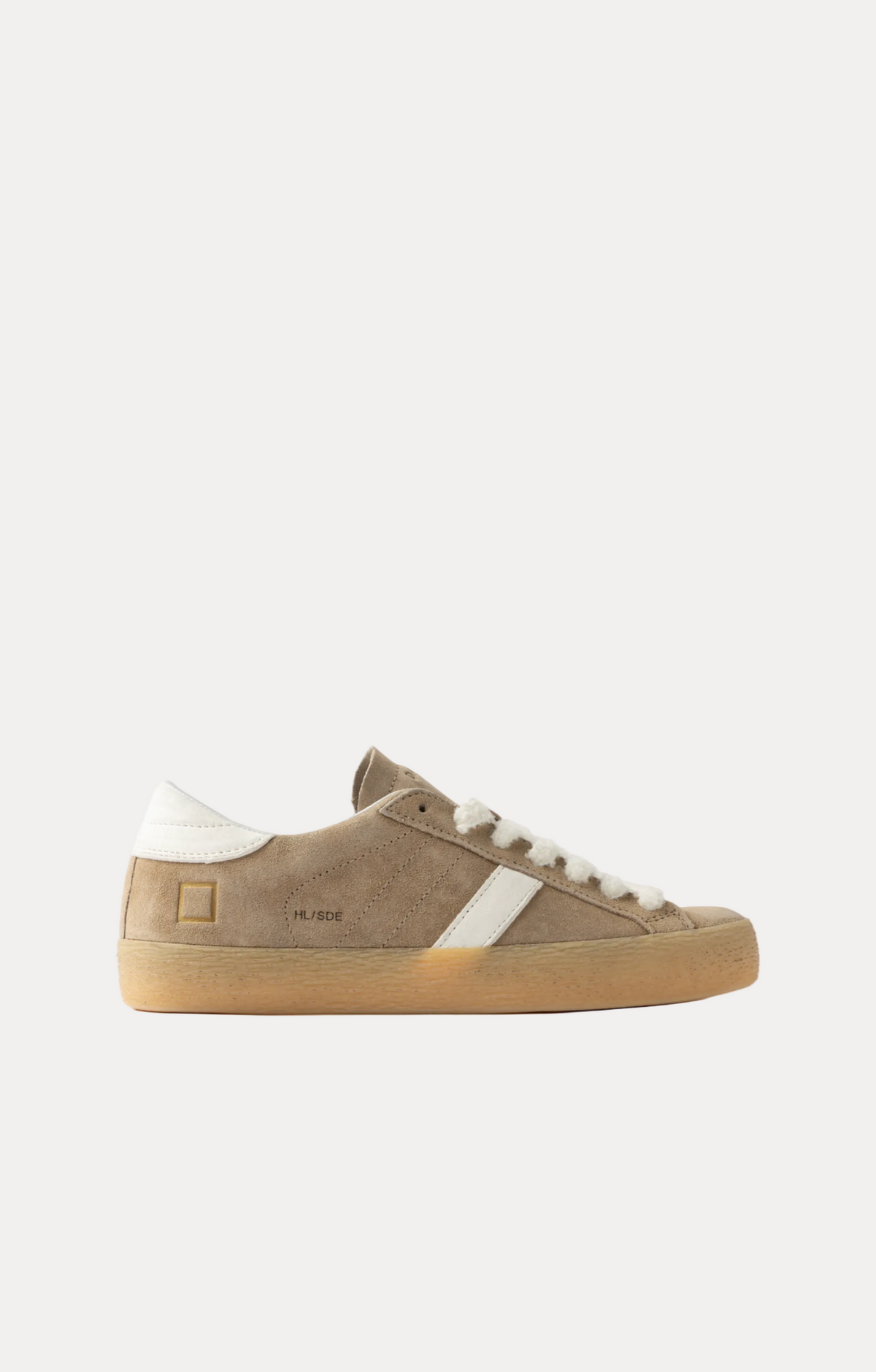 A low-top sneaker in taupe suede with a white side stripe, white laces, a white heel tab, and a gum sole, shown in profile against a light gray background.