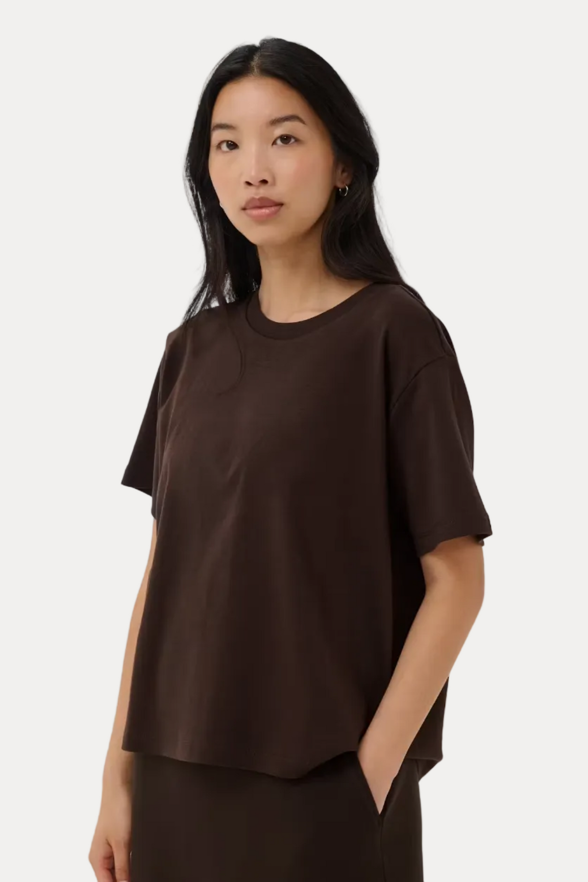 Woman wearing a brown t-shirt and skirt on a white background