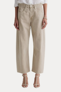 Person wearing beige pants and a white shirt on a light gray background